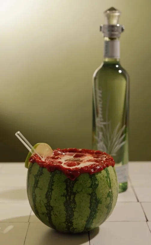 Tequila Sandía servido dentro de una sandía baby con escarchado de tamarindo
